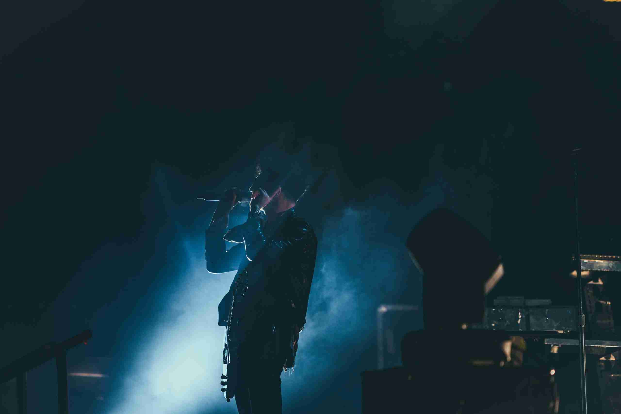 Rock star holding the mic in front of smoke and light